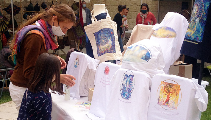 T-Shirts de gauche à droite: "La Terre nous aime" de Lola S - "La Rose" de Dolorès Soleymieux - "Home" et "Alcyone éternelle" de François Schlesser - "Amour est ma véritable nature" de Myrrha - "Arbre Solaire" de Virginie Dubois Gonati